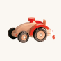 Ostheimer Wooden Tractor with red wheel arches, steering wheel and string attachment, on a cream background 