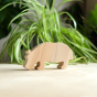 O-WOW eco-friendly maple wood hippo toy on a wooden worktop in front of a green house plant