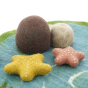 Close up of the Papoose yellow and red starfish toys on a blue play mat in front of some Papoose rocks