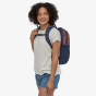 Picture of a female model wearing the Patagonia Refugio backpack from a side view. Background of the picture is white. Bag in the picture is navy. This colour is not sold on website, colour used for style reference only.
