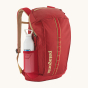 Patagonia Recycled Black Hole Backpack 25L in Touring Red with a reusable water bottle in the mesh side pocket on a cream background 