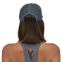 Woman stood backwards on a white background wearing the Patagonia eco-friendly teal blue duckbill trucker cap 
