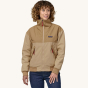 A woman models the front of the Patagonia Women's Shelled Synchilla Jacket - Tinamou Tan.