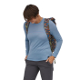 Close up of woman wearing the Patagonia mushroom print arbor 30 litre roll top backpack on a white background