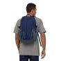 Man stood wearing the eco-friendly Patagonia classic navy refugio backpack on a white background