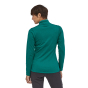 Woman stood backwards wearing the Patagonia R1 daily zip neck thermal fleece top on a white background