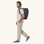 Side profile of a man wearing the Patagonia Fieldsmith Lid Backpack to show the backpack fit. 