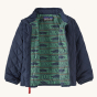 An open Patagonia Little Kids' Nano Puff Jacket - New Navy, showing the inside of the jacket. The jacket in the photo is navy blue, with a green Hog print lining
