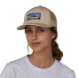 Front view of adult wearing the Patagonia P-6 Logo Trucker Hat in an Oar Tan colour way 