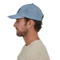 Side profile of a man wearing the Patagonia 73 skyline trad cap hat in the light plume grey colour on a white background