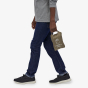 Picture of model carrying the tote pack packed away into its won pocket. Picture background is white.