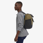 Picture of model wearing the backpack (side view). Picture background is white.