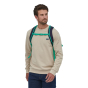 A man wearing the Patagonia Refugio Day Pack 26L - Classic Navy/Fresh Teal, stood upright, front top view, on white background