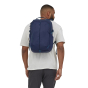 A man wearing the Patagonia Refugio Day Pack 26L - Classic Navy, stood upright, top back view, on a white background
