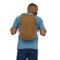 A man wearing the Patagonia Refugio Day Pack 26L in Coriander Brown, stood upright, rear top view, on white background
