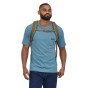 A man wearing the Patagonia Refugio Day Pack 26L in Coriander Brown, stood upright, front top view, on white background
