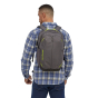 A man wearing the Patagonia Refugio Day Pack 26L in Forge Grey, stood upright, rear top view on white background