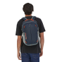 A man wearing the Patagonia Refugio Day Pack 26L in Tidepool Blue, stood upright, rear top view, with white background