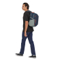 A man wearing the Patagonia Refugio Day Pack 26L in Tidepool Blue, stood upright, side view, with white background