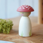 Peepul plastic-free handmade wooden toadstool peg doll toy on a shelf for scale.