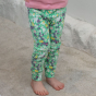 child wearing green organic cotton leggings with the spring meadow print from piccalilly