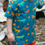 close up of a child wearing blue organic cotton children t-shirt with wild horses print from piccalilly 