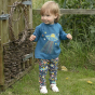 Young child stood on some grass wearing the Piccalilly organic cotton embroidered alien top
