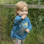 Close up of young child running with their arm out, wearing the Piccalilly organic cotton alien top