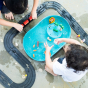 Overhead shot of children playing with the Plan Toys Water Play Set and rubber road - an exciting play tray inspiring creative water play and is a fabulous sensory toy for toddlers. 