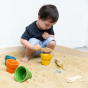 Toddler playing in the sandpit with the PlanToys Flower pot set.