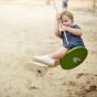 Child swinging outside on the PlanToys Saucer Disc Swing