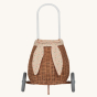 Olli Ella Rattan Bunny Luggy with Lining – Gumdrop. A beautifully woven Luggy roll along basket with a light peach lining and gum drop detail, with a fluffy bunny tail, on a cream background.