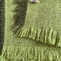 Close up of the tassels on the Respiin green woollen throw blanket