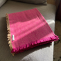 Respiin mulberry purple woollen throw folded on a grey sofa