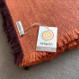 Close up of the recycled wool label on the Respiin large orange throw blanket