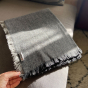 Respiin dark grey recycled wool throw folded on a grey sofa