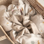 Roommate organic cotton soft bunny comfort cloth toy laying on a grey duvet in a moses basket