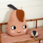 Roommate eco-friendly children's pear cushion on a pink bed next to a soft ball toy