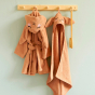 Roommate organic cotton hooded bunny baby towel and bathrobe hanging from a wooden hook on a grey wall