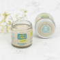 two Salt of the Earth, Plastic Free Deodorant balms (Unscented), one stood upright and open, the other laid down. On a white marble background with blossom laid behind pots