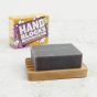Hand Blocks purple Mango and Passionfruit soap bar and box, with the soap block on a wooden soap dish in the foreground