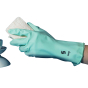 Close up of a hand in a teal rubber glove holding a Seep natural cellulose kitchen sponge on a white background