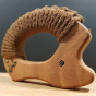A closer view of the SENGER wooden grasping and teething Hedgehog made with oiled cherry wood and brown yarn, on a dark grey background and a wooden table