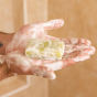 A person with a Shower Blocks solid gel bar lathered up in their hands