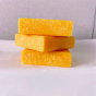 Stack of Shower Blocks ginger and honey solid hair wash bars for itchy scalps on the side of a bath