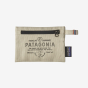 Patagonia Small Zippered Pouch - Forge Mark: Bleached Stone, a cream zippered pouch with a black zip across the front top, a vintage style Patagonia label and security tag, on a white background