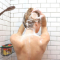 Picture of a woman with blonde hair using the Lamazuna Nutri Glow solid shampoo to wash her hair.