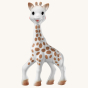 Sophie la Girafe® - Once Upon A Time 100% Natural Rubber Original Giraffe Teether. A cute, smiling giraffe teether on a cream background