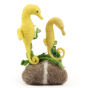 A closer look at the detail on The Makerss Needle Felt Seahorses. Two beautifully crafted yellow Seahorses with green seaweed details, next to each other on a grey and white pebble
