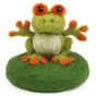 A fully made The Makerss - Amiguwoolli Tiny Frog Mini Needle Felt Figure. The frog is made from lime green woolen felt, with a white belly, yellow finger and toe pads, stick in eyes outlined in orange, and sat on a dark green felted base